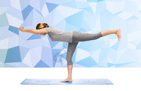 健身,运动,人健康的生活方式妇女瑜伽战士姿态垫子上的低聚背景图片