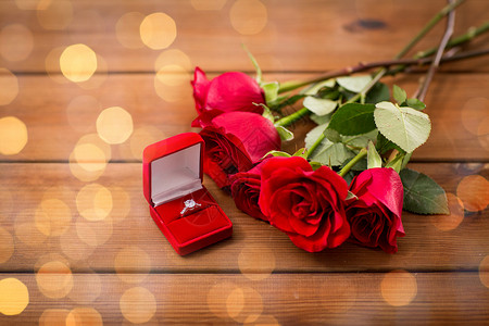 爱情,求婚,情人节假期的礼品盒与钻石订婚戒指红色玫瑰木材上背景图片