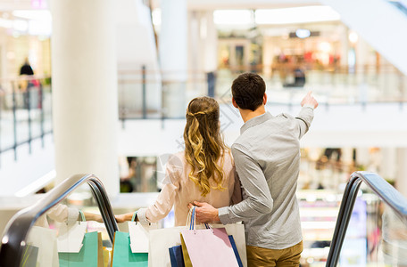 销售,消费主义人的快乐的轻夫妇,购物袋下降,扶梯手指商场图片