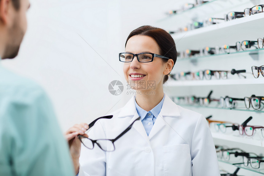 保健,人,视力视力女光学师光学商店向男展示眼镜图片
