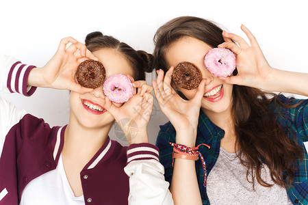 人,朋友,青少友谊的快乐的微笑,漂亮的十几岁的女孩与甜甜圈,脸玩得开心背景图片