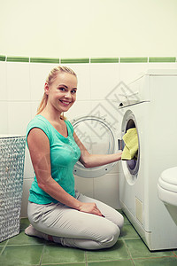 人,家务,洗衣家务快乐的女人家里把衣服放进洗衣机高清图片