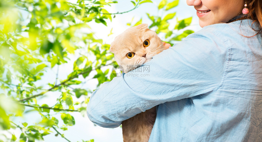 宠物,动物,护理人的亲密的快乐女人抱着苏格兰折叠小猫自然绿色的背景图片