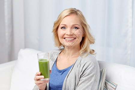 健康饮食,素食,节食,排人们的观念微笑的中妇女喝绿色新鲜蔬菜汁冰沙璃家里图片