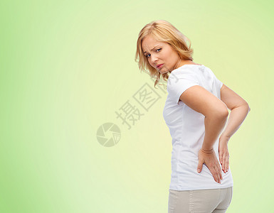 人,医疗保健,背痛问题的幸的女人遭受疼痛的背部的绿色自然背景图片
