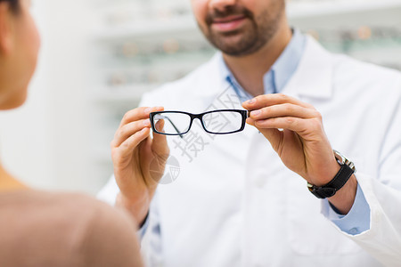 医疗保健,人,视力视力近距离的眼镜师眼镜给妇女光学商店图片