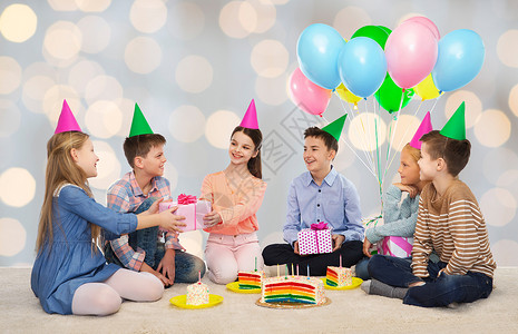 生日聚惠童,假期,庆祝,友谊人的快乐的微笑孩子派帽子与蛋糕送礼物生日聚会上的灯光背景背景