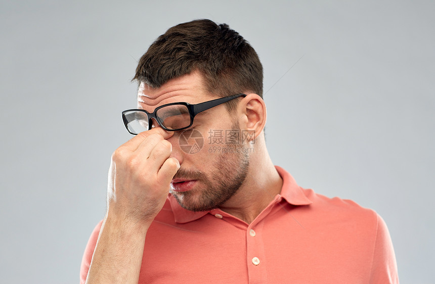 商业,人,视觉过度工作的疲惫的男人戴着眼镜,摸着灰色背景上的鼻梁图片