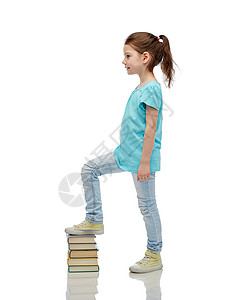 童,学校,教育人的快乐的小女孩踩书堆上图片