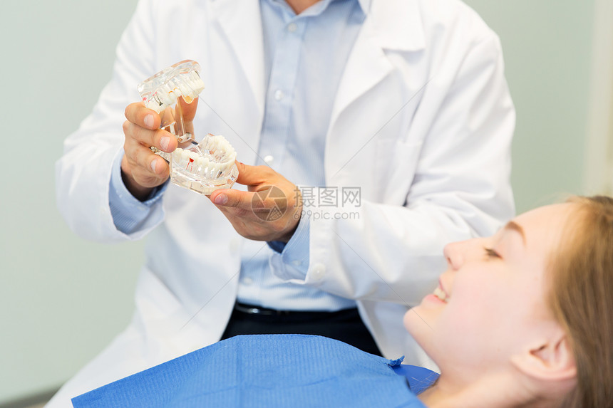 人,医学,口腔科保健快乐的男牙医下巴牙齿布局给病人女孩牙科诊所办公室图片