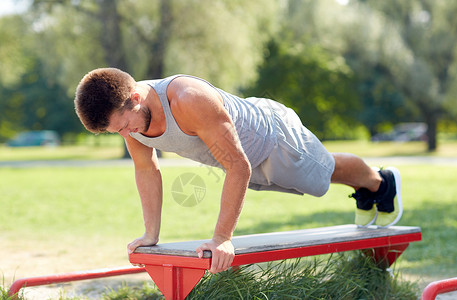 健身,运动,锻炼,训练生活方式的轻人夏季公园的长凳上俯卧撑图片