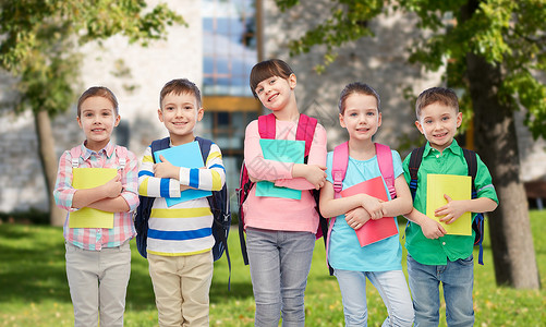 童,学前教育,学人的群快乐微笑的小孩子,带着书包笔记本夏天的校园背景下图片