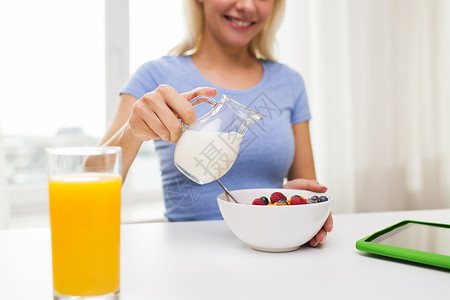 健康的饮食,食物人的密切妇女水壶倒牛奶碗与早餐家里背景图片