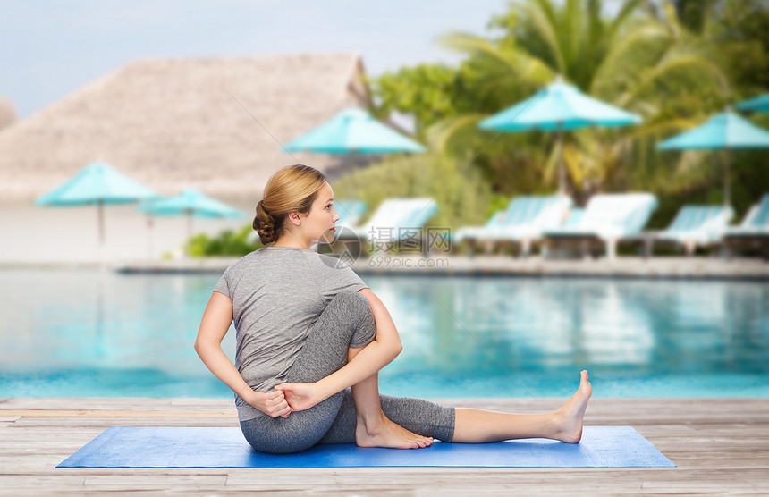 健身,运动,人健康的生活方式妇女瑜伽垫子上的海滩游泳池背景图片