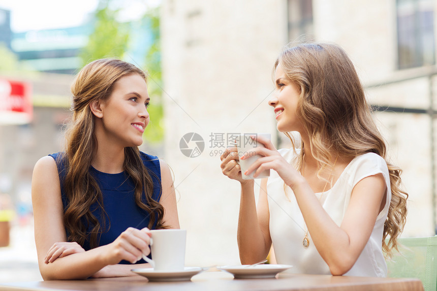 人,沟通友谊的微笑的轻妇女喝咖啡茶,户外咖啡馆交谈图片