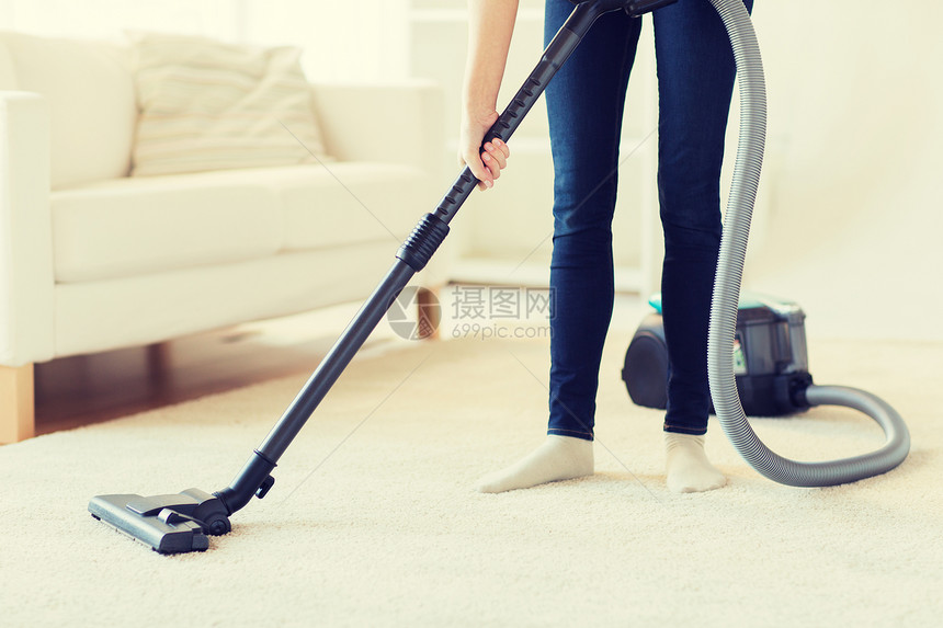 人,家务家务妇女与腿吸尘器清洁地毯家里图片