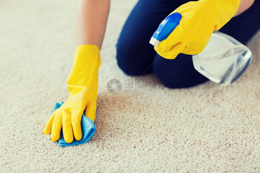 人,家务家务妇女橡胶手套与布洗涤剂喷雾清洁地毯家里图片