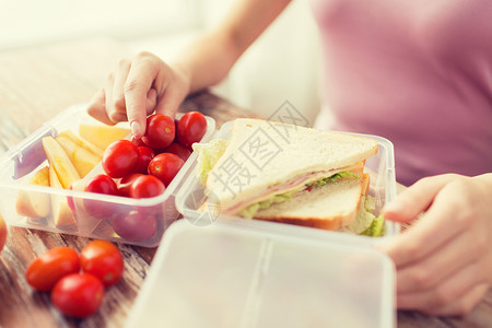打开三明治健康的饮食,储存,饮食人们的密切妇女与食品塑料容器家里厨房背景