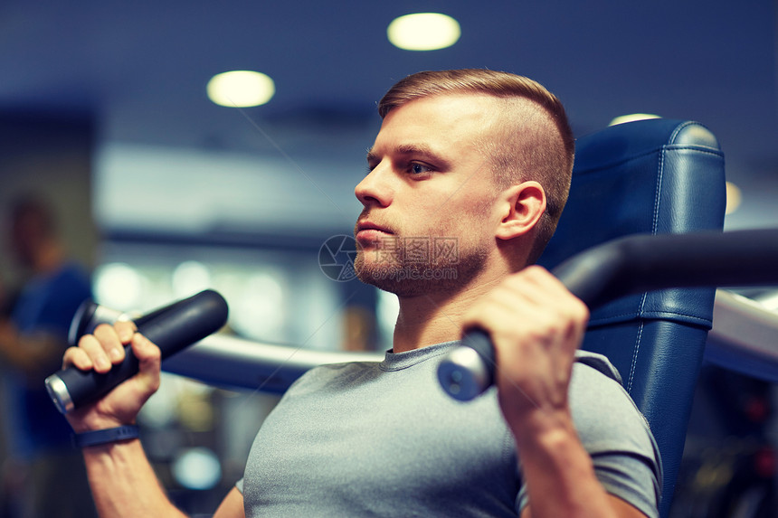 运动,健身,健美,生活方式人的男人锻炼弯曲肌肉健身机图片