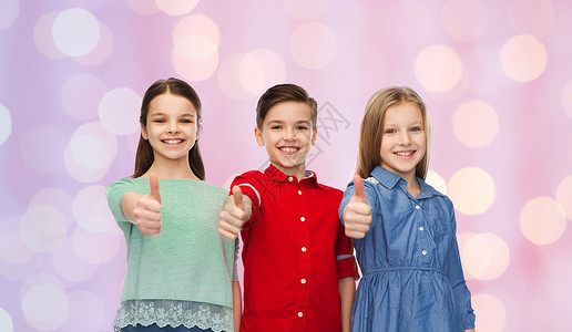 童,时尚,手势人的快乐的微笑孩子们粉红色的节日灯光背景上竖大拇指图片