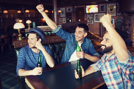 人,休闲,友谊单身汉聚会的快乐的男朋友喝瓶装啤酒,举手酒吧酒吧支持足球比赛图片