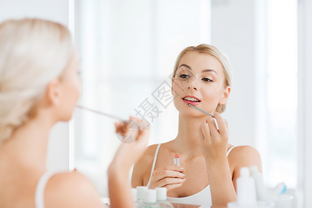 美容,化妆,化妆品,早上人的微笑的轻女人与口红喷头,化妆镜子家里的浴室图片