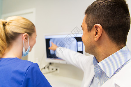 人,医学,口腔科保健的牙医助理看X射线监测屏幕上的牙科诊所图片