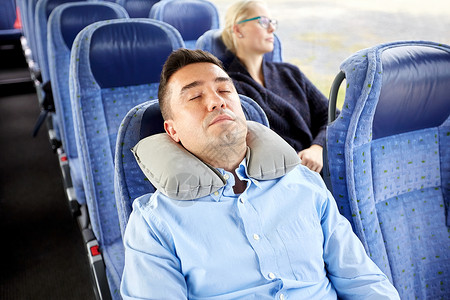 交通,旅游,休息,舒适人的男人睡旅行巴士与颈充气枕头图片