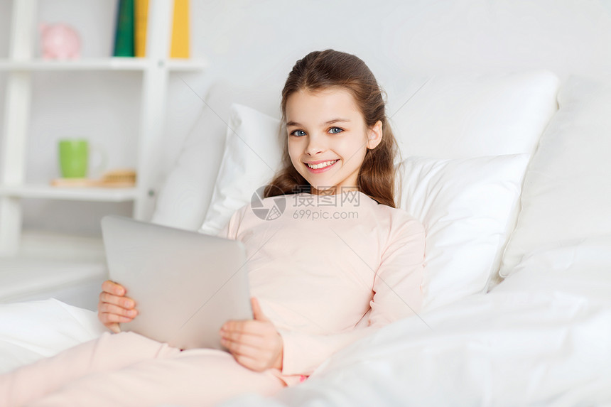 人,孩子,休息技术快乐的微笑女孩躺床上,平板电脑电脑电脑家里图片
