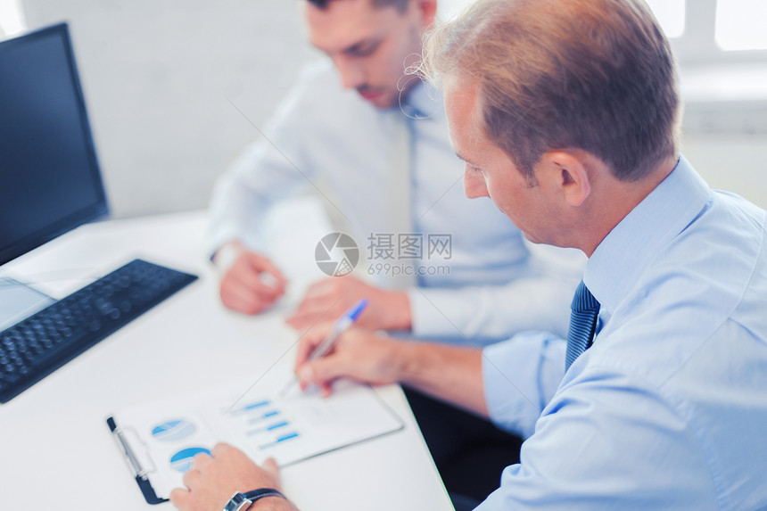 商务办公室商人与笔记本讨论图表的会议商人会议上带着笔记本图片