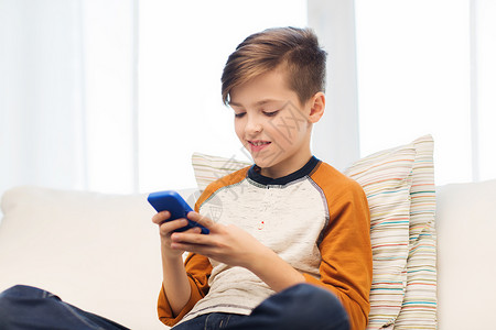 休闲,儿童,技术,互联网交流人的微笑男孩与智能手机短信家玩游戏图片