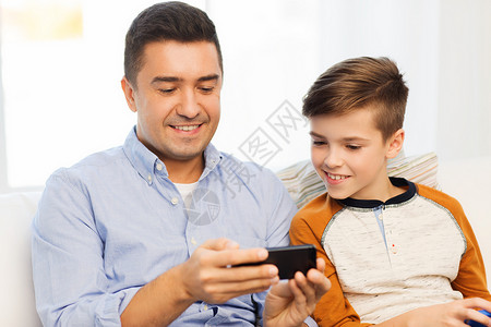 休闲,技术,家庭人的快乐的父子与智能手机短信家玩游戏背景图片