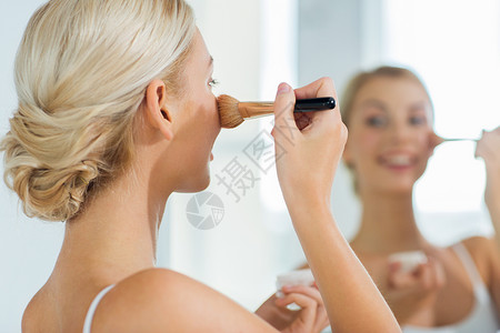 美容,化妆,化妆品,早上人的特写微笑的轻女人化妆刷粉底家里的浴室镜子图片