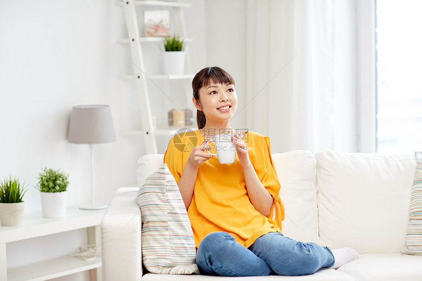 人饮料休闲快乐的亚洲女人坐沙发上,家用杯子杯子喝茶图片