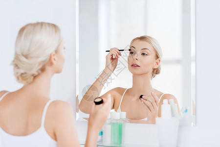 美容,化妆,化妆品,早晨人的轻的女人用化妆刷涂眼影,家里的浴室照镜子图片