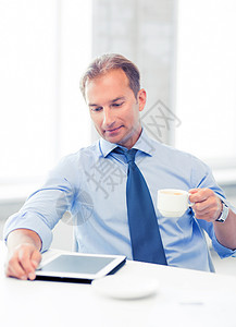 微笑的商人与平板电脑办公室喝咖啡办公室里平板电脑咖啡的商人图片