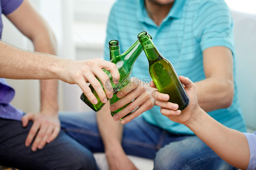 友谊,酒精,人,庆祝节日的亲密的男朋友家里喝酒碰啤酒瓶图片