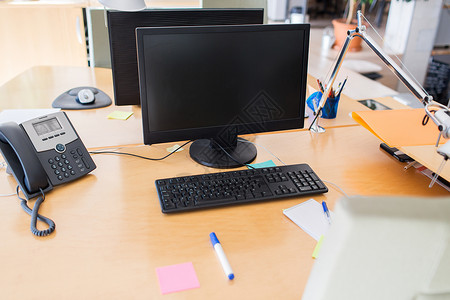 技术商业广告办公室桌子上空白黑屏的计算机背景图片