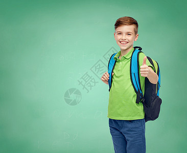 童,教育人的快乐的微笑学生男孩与书包绿色学校粉笔板背景图片