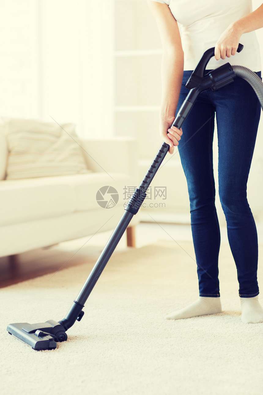 人,家务家务妇女用吸尘器清洁地毯家里图片