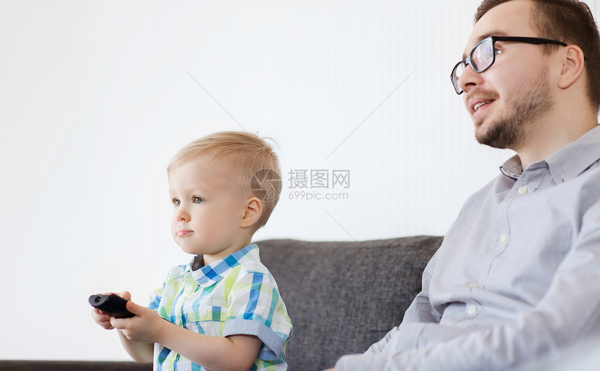 家庭,童,父亲,技术人的快乐的父亲小儿子与遥控器家看电视图片