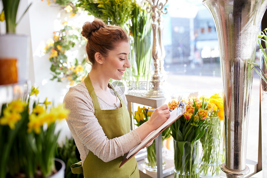 人,销售,零售,商业花卉快乐微笑的花店妇女与剪贴板写作笔记订单花店图片