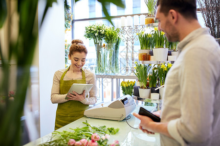 人,购物,销售,花卉消费观念快乐微笑的花店妇女与平板电脑电脑男子钱包花店背景图片