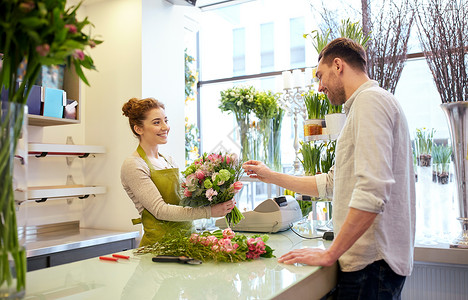 人,购物,销售,花卉消费观念快乐微笑的花店妇女为男人顾客制作花图片