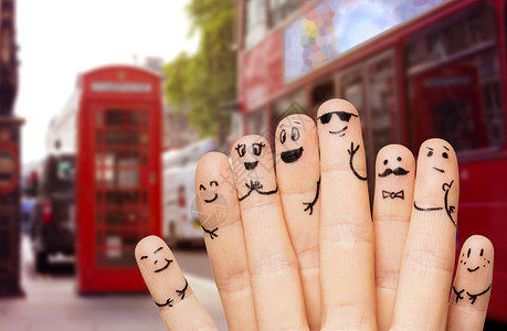 双层车旅行,旅游,家庭,人身体部位的特写两只手手指与微笑的脸伦敦城市街道红色公共汽车背景背景