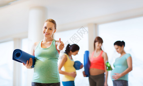怀孕,运动,健身,人们健康的生活方式快乐的孕妇健身房里用垫子竖大拇指图片