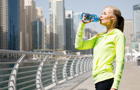 健身,运动,人健康的生活方式妇女饮水后,运动迪拜城市街道滨水背景图片