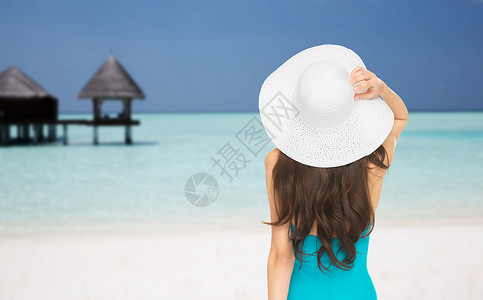 人们,暑假,旅游,旅游度假的穿着泳衣太阳帽的女人马尔代夫海滩回来,平房的背景图片