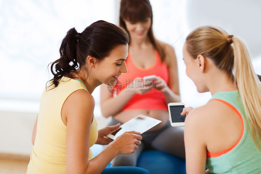 怀孕,运动,健身,人健康的生活方式群快乐的孕妇用平板电脑智能手机坐健身房的球上图片