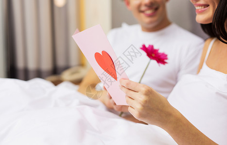 爱,关系,假期,情人节人的床上亲密的幸福夫妇与明信片鲜花图片
